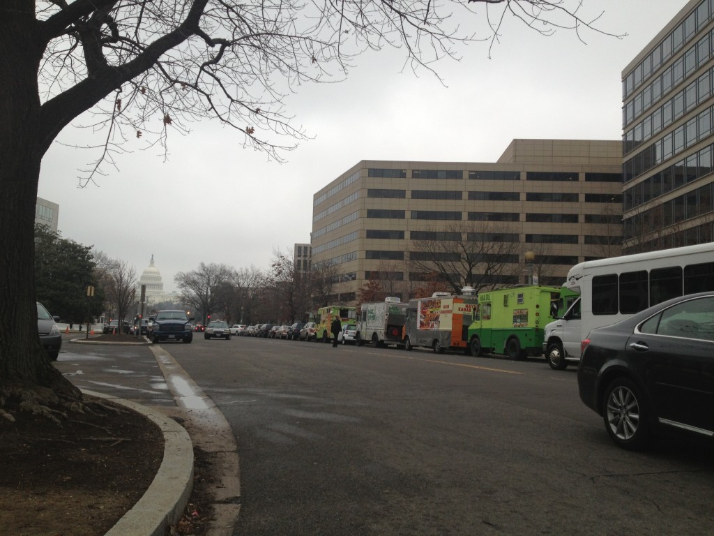 A line of food trucks with the United States Capitol in the background. 